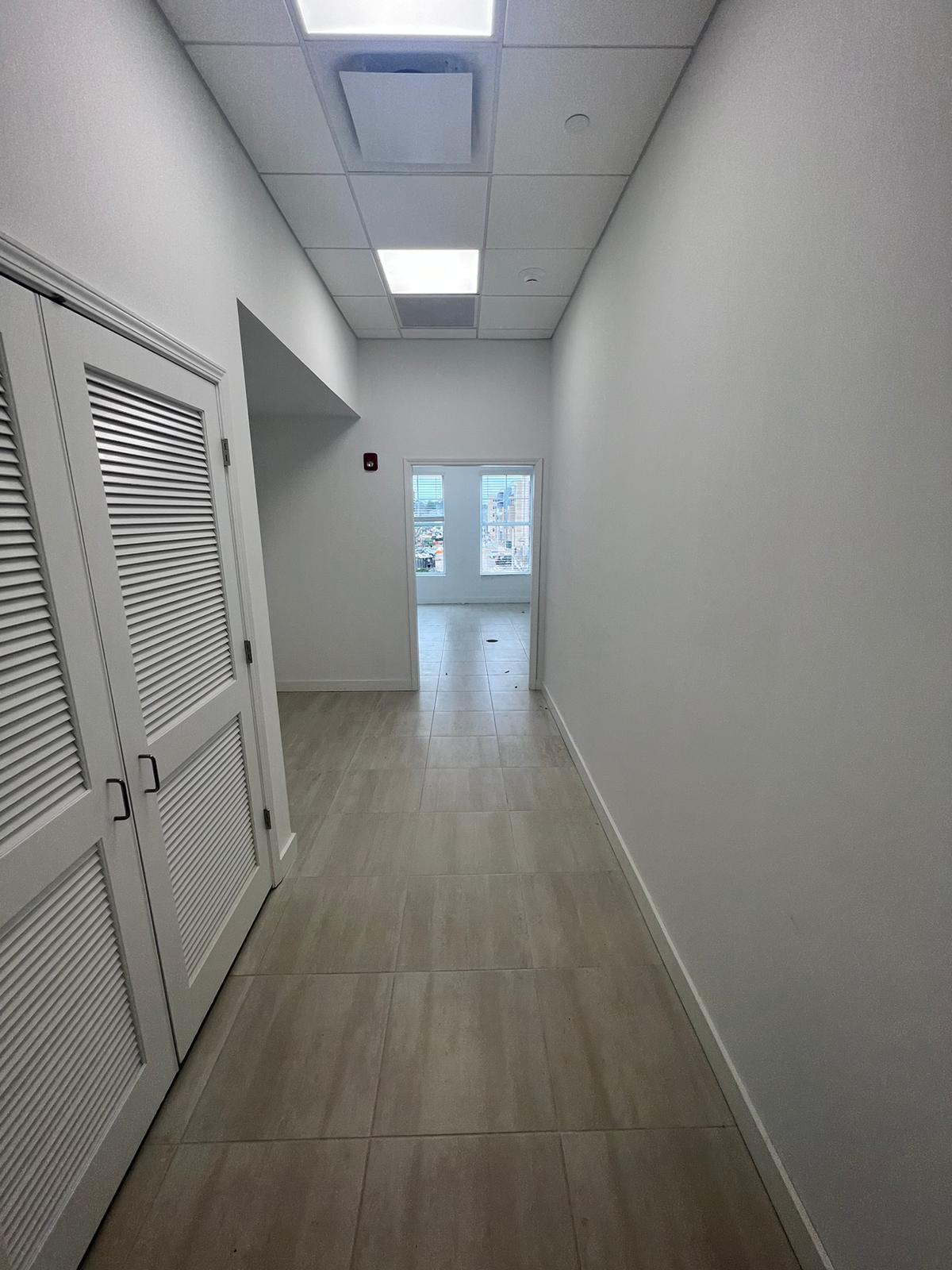 Completed tiled common area hallway repaint with finished trim and doors