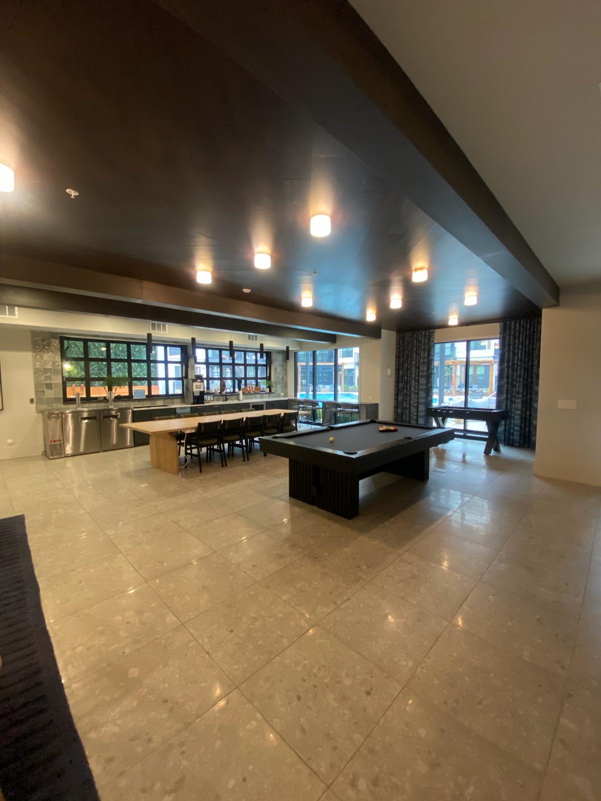 Clubhouse entertainment area with pool table, bar and community seating