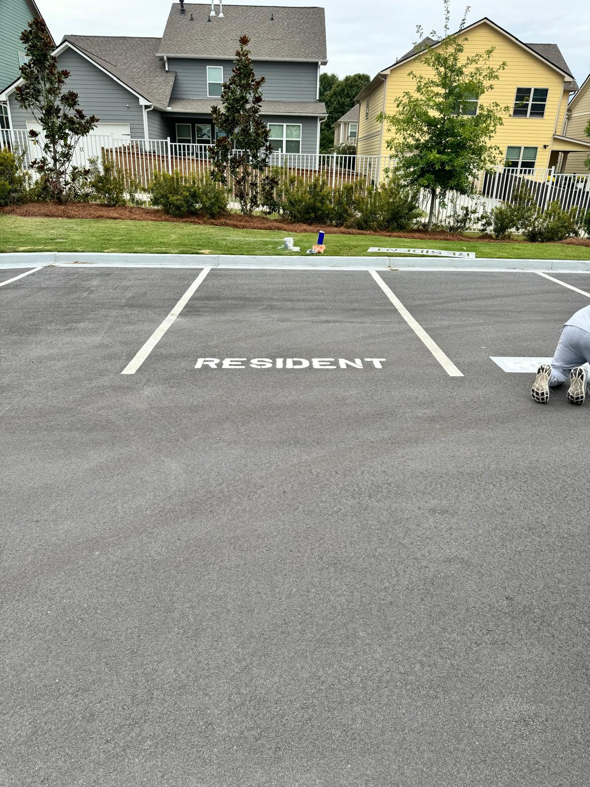 Completed RESIDENT parking space marking on fresh asphalt
