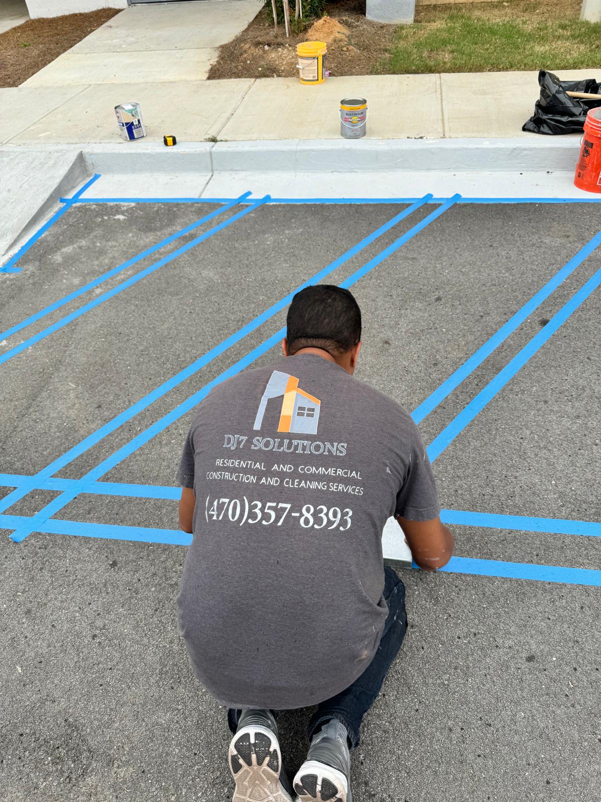 DJ7 Solutions team member taping layout lines for parking lot striping
