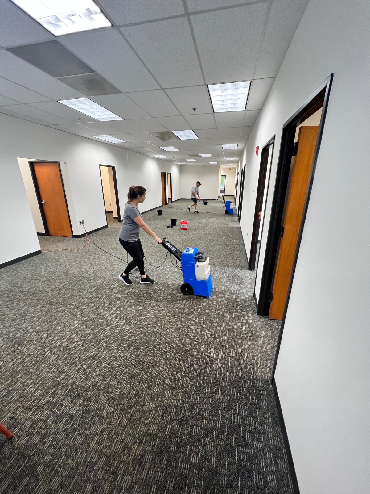 DJ7 Solutions crew operating commercial carpet cleaning equipment in an office suite