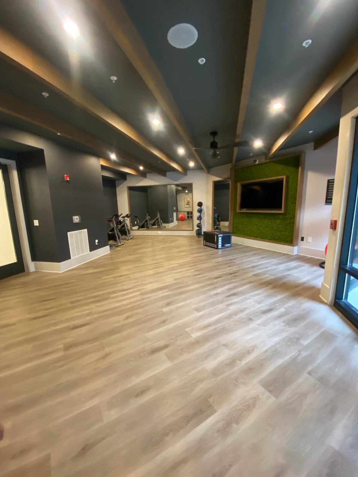 Multifamily fitness center and amenity space with hard flooring and equipment