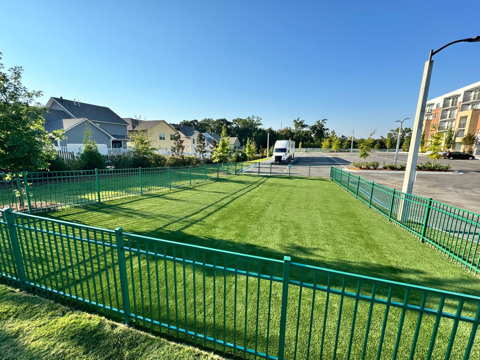 Wide view of a finished dog park artificial turf installation at a multifamily community